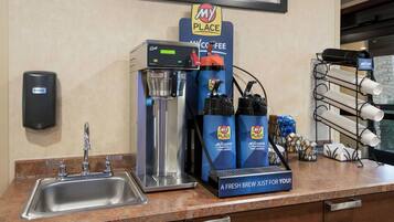 A coffee station with a coffee machine, a water dispenser, and a coffee grinder.