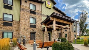Een hotel met een stenen gevel, meerdere ramen en een overdekt terras.