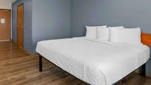 Ein Hotelzimmer mit einem großen Bett, Holzboden und einer blauen Wand.