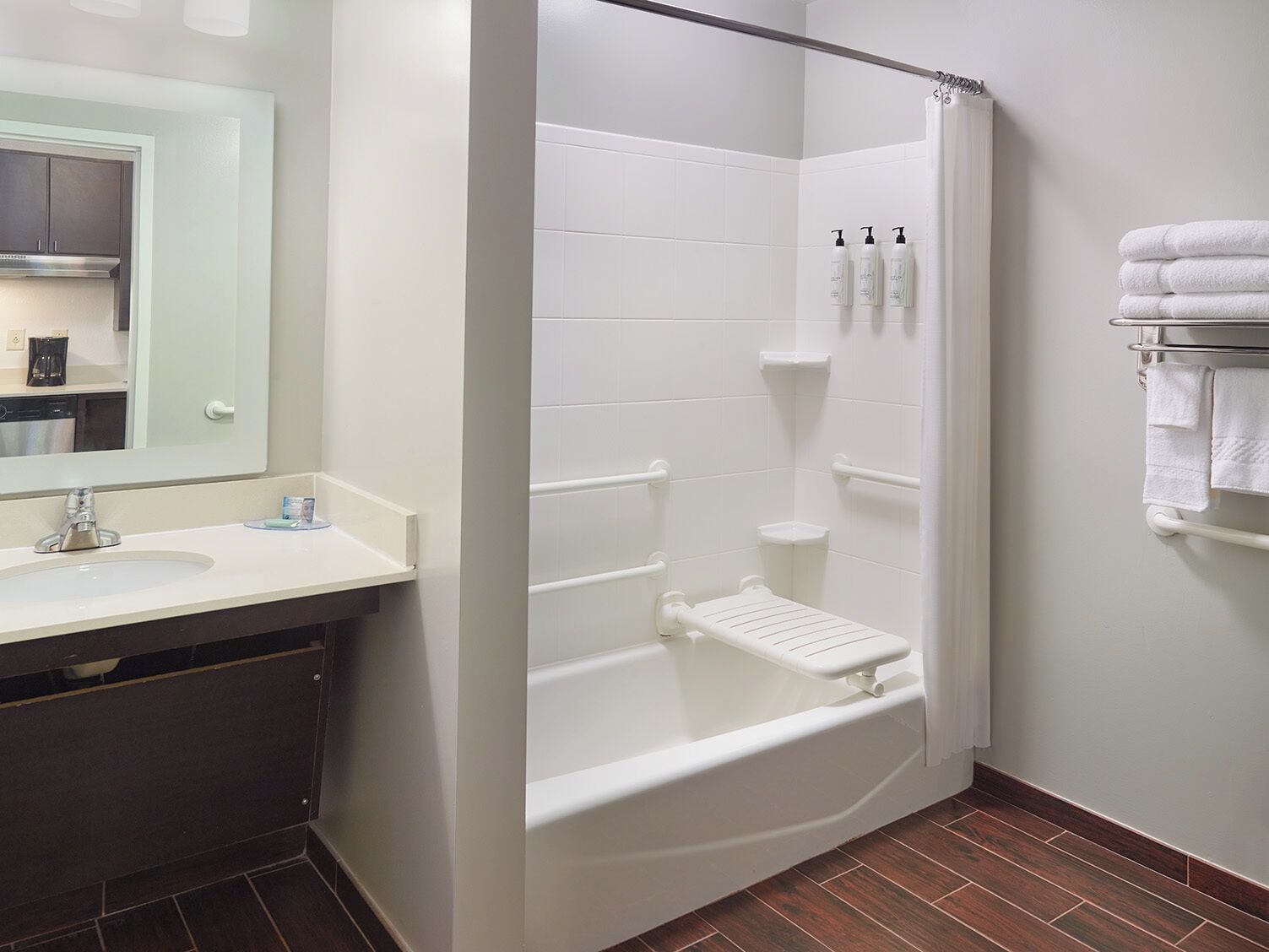 A bathroom with a bathtub, a shower, a sink, and a mirror.