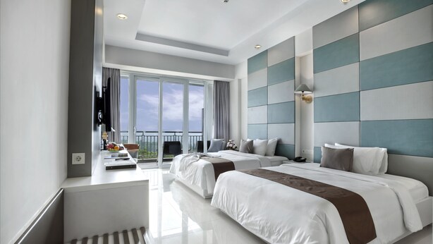 A modern hotel room with two beds, a balcony, and a large window.