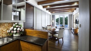 A modern kitchen with a wooden countertop, a sink, and a dining area with a table and chairs.