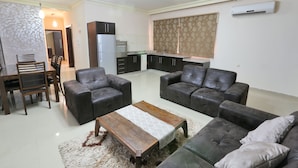 A living room with two sofas, a coffee table, and a dining area with chairs and a table.