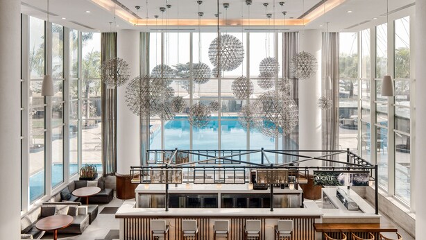 A modern bar area with seating, large windows, and decorative spherical light fixtures.