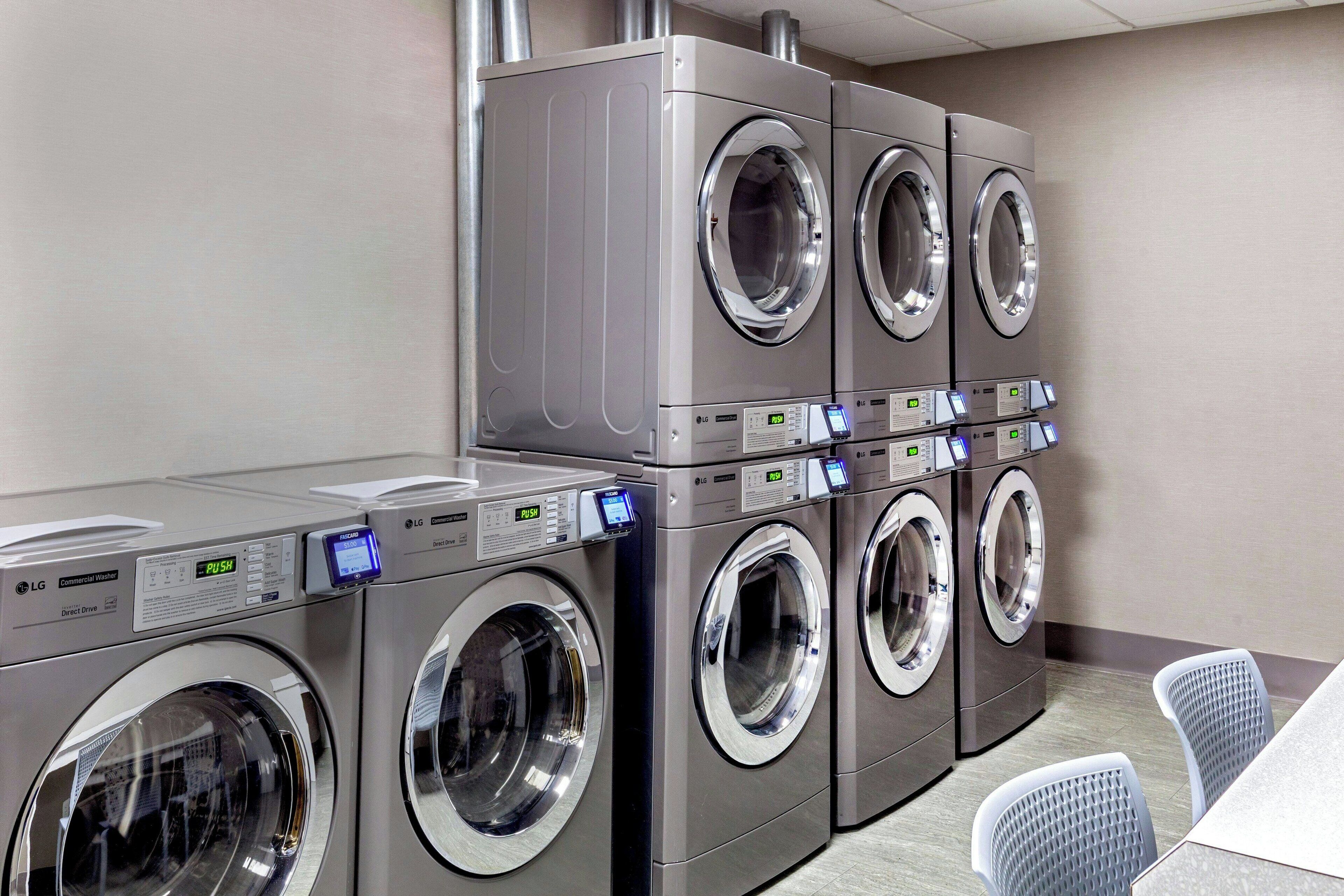 A row of LG commercial washers in a hotel laundry room.