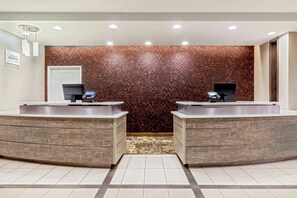 A reception area with two sinks, a patterned carpet, and a brick wall. - Residence Inn Nashua (Nashua)