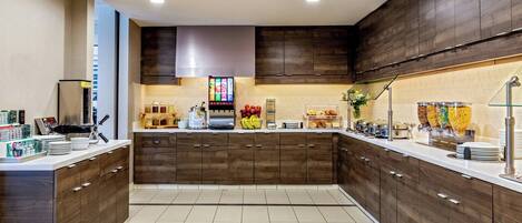 A modern kitchen with dark wood cabinets, a central island, and a breakfast bar.