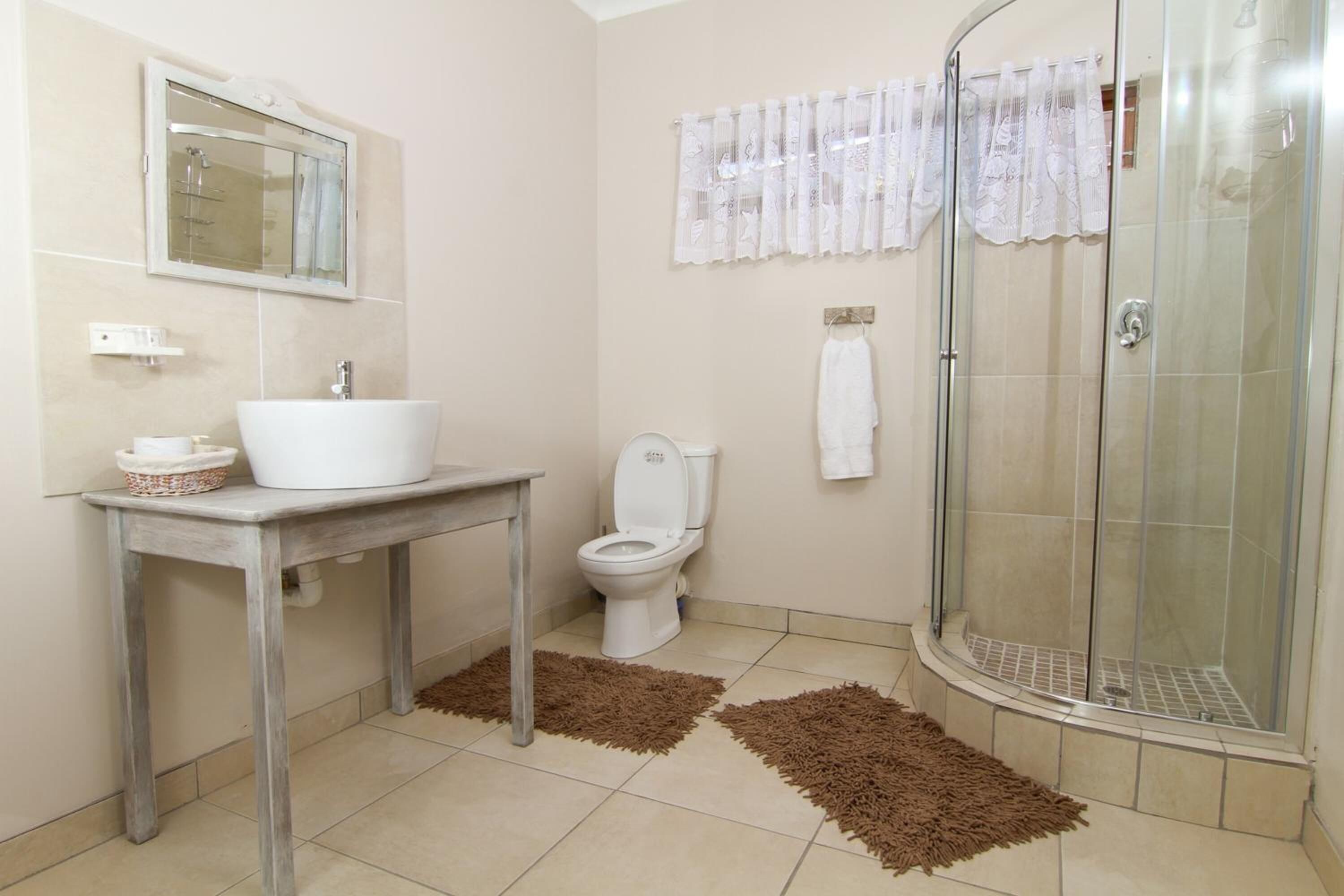 A bathroom with a sink, toilet, and shower.
