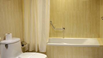 A bathroom with a toilet, a sink, a bathtub, and a shower curtain.