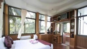 Une chambre avec un grand lit, un bureau et un miroir.