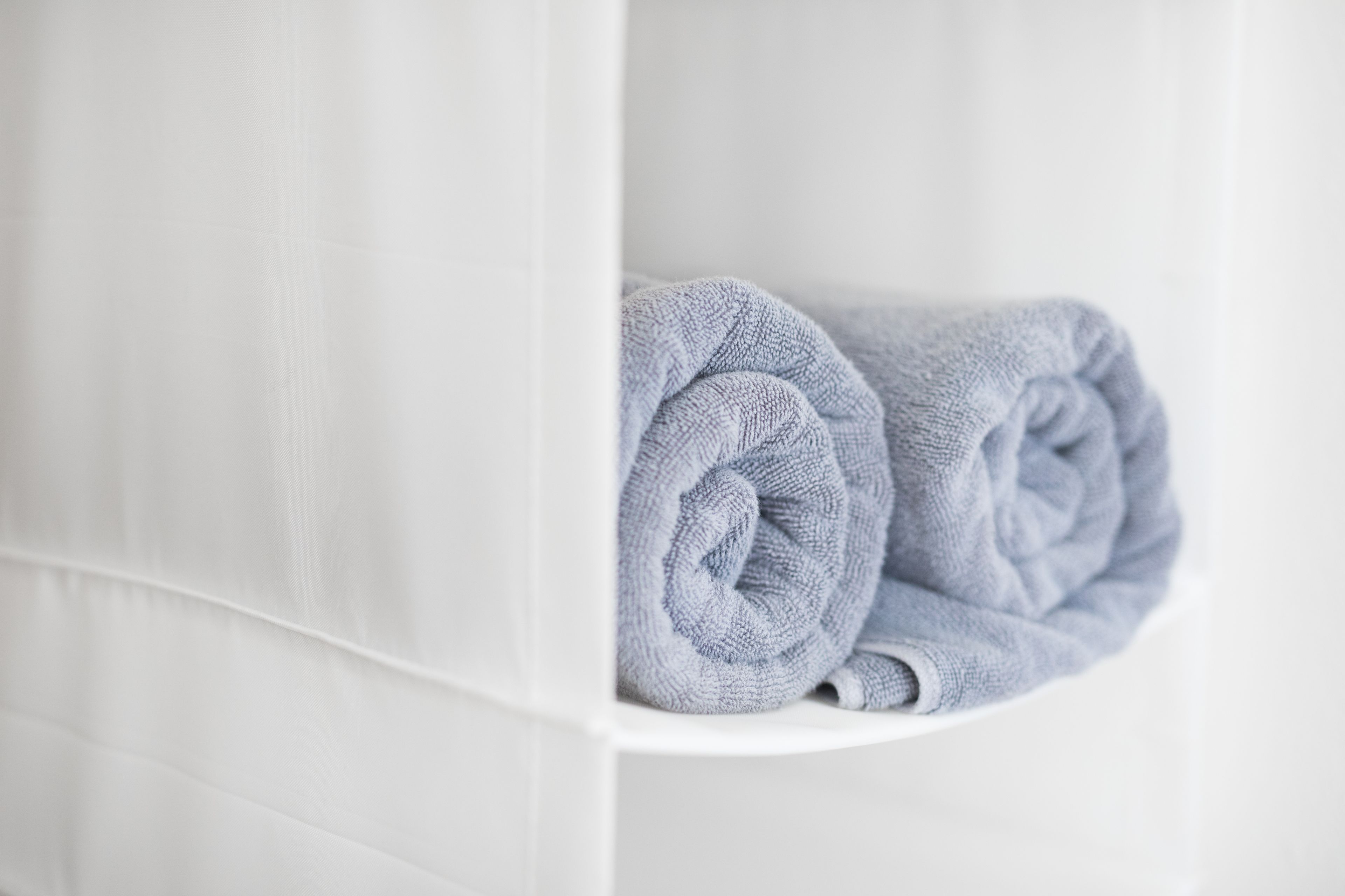 Una toalla doblada con cuidado en un baño de color blanco.