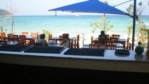 A seaside restaurant with outdoor seating, overlooking the ocean. - VIVA on the Beach Hotel (Ko Pha-ngan)