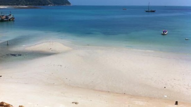 A beach with clear water, a sandy shore, and boats in the distance. - VIVA on the Beach Hotel (Ko Pha-ngan)