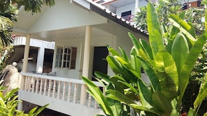 Relax in a serene outdoor space surrounded by lush greenery and enjoy a meal or quiet moment at a small table and chairs.