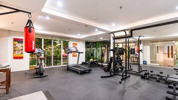 A modern gym with cardio equipment, weightlifting stations, and a punching bag.