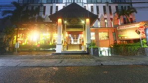 A hotel entrance with a covered walkway, a signboard, and a staircase leading to the entrance. - Grand Santhi Hotel (Denpasar)