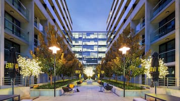 Relax in a serene outdoor space with a central seating area, beautifully manicured garden, and modern architecture.