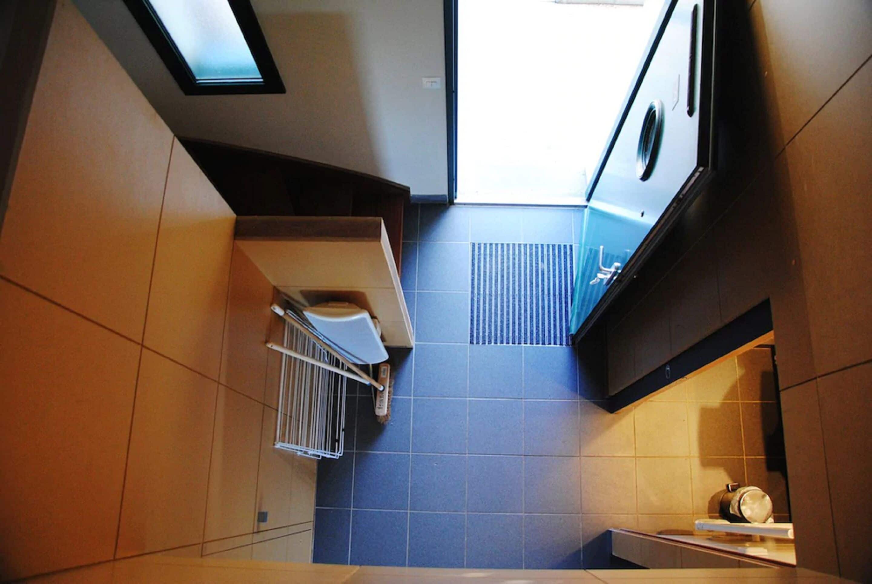A modern kitchen with a skylight, a built-in oven, and a small countertop.