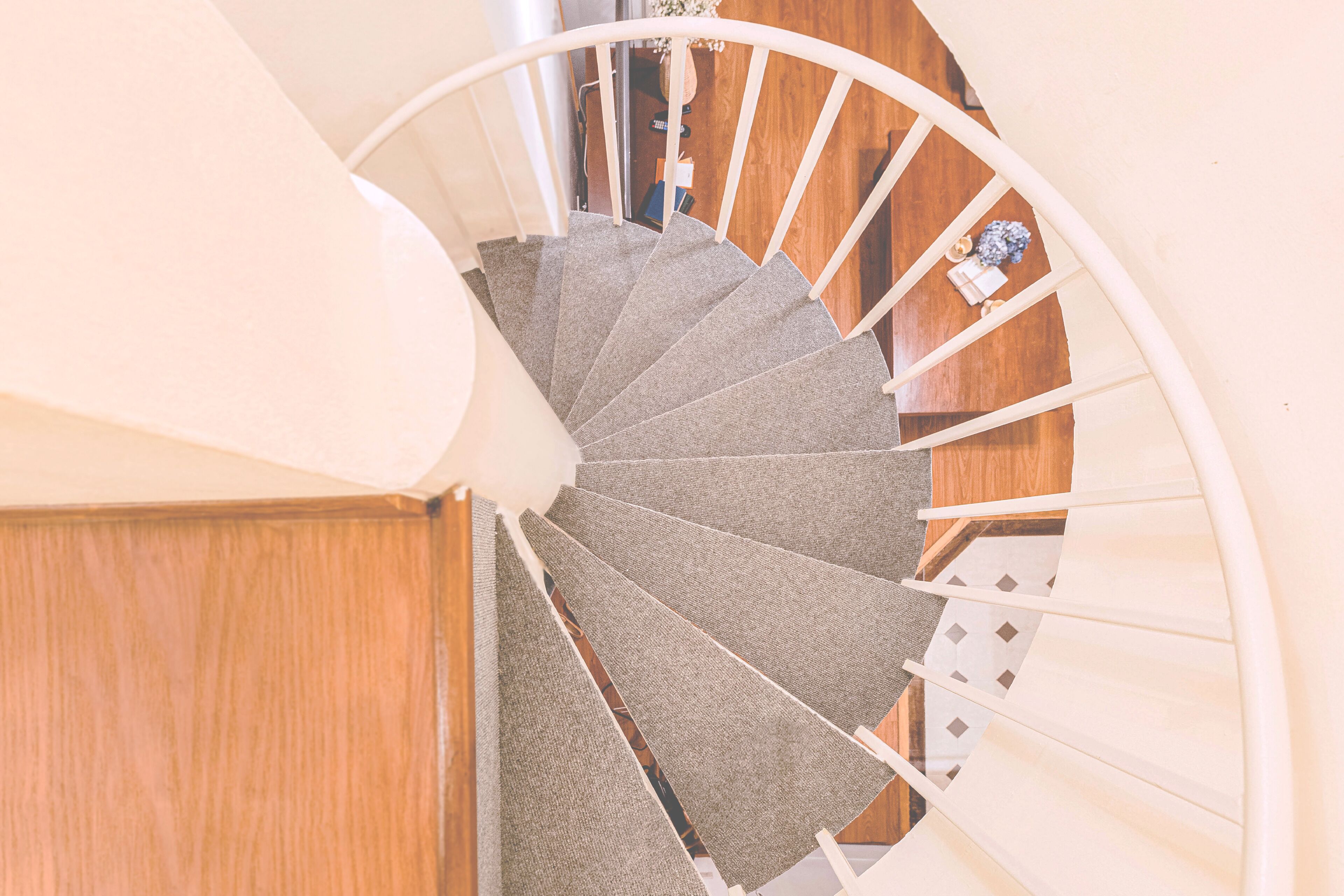 Un escalier en colimaçon avec des marches en bois et une rampe blanche.