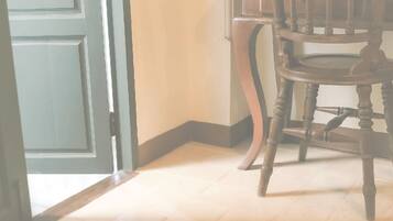 A wooden chair in a room with a light-colored floor and a partially open door.