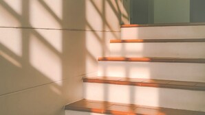 A staircase with wooden steps and a white wall. - Yesterday Hotel (Chiang Mai)