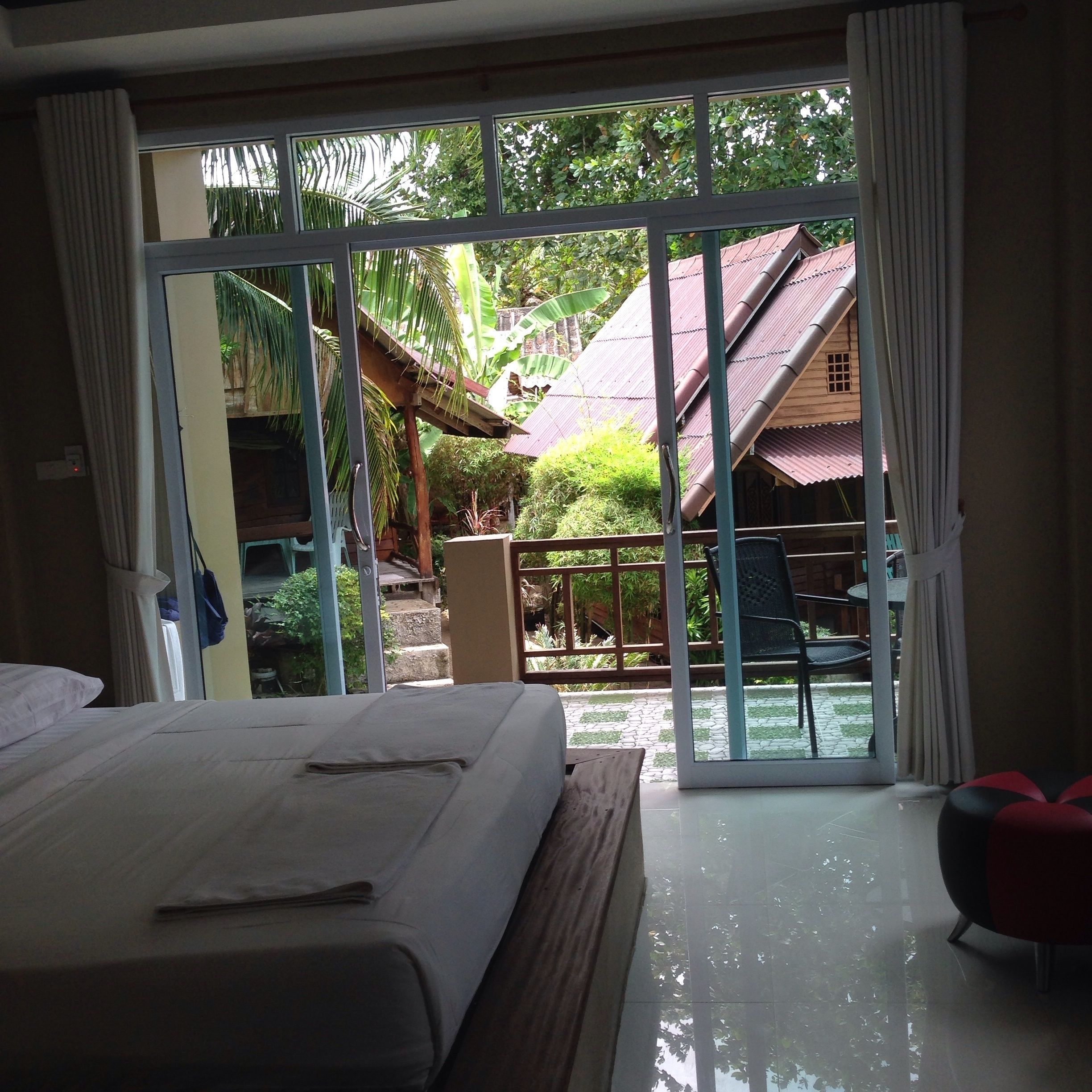 Ein Hotelzimmer mit Bett, Gartenblick und einer Schiebetür zum Außenbereich.