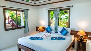 A well-lit bedroom with a large bed, two bedside tables, and curtains on the windows. - Zama Resort (Ko Pha-ngan)