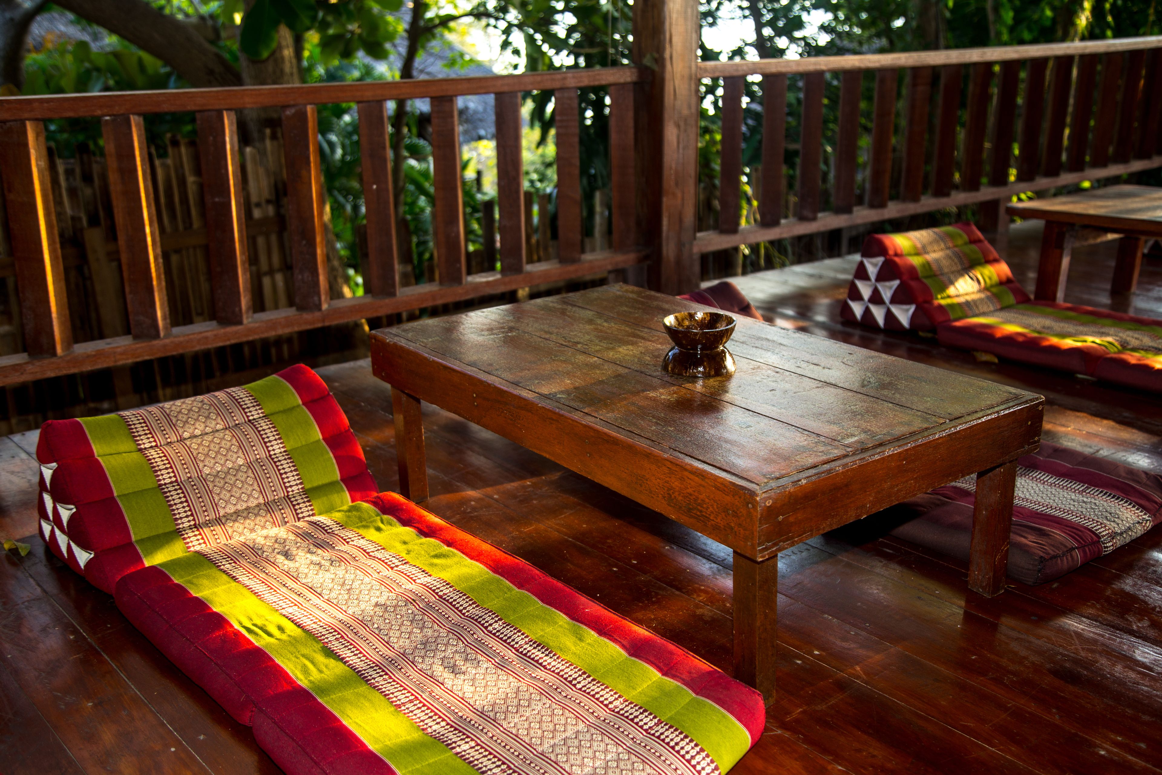 A wooden deck with a bench and a table, surrounded by a wooden fence.