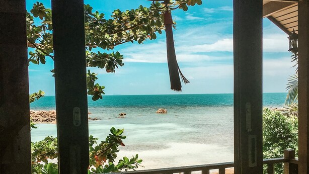 A covered outdoor seating area with a view of the beach. - Zama Resort (Ko Pha-ngan)
