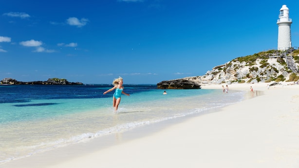 A beach with a lighthouse, clear blue water, and rocky outcrops. - Stay Rottnest (Rottnest Island)