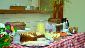 Una mesa de buffet con diversos alimentos, como pan, fruta y un pastel.