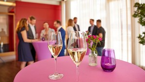 A round table with two wine glasses and a purple candle holder.