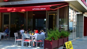 An outdoor seating area with tables and chairs at Flottwell Berlin.