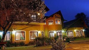 A two-story building with multiple windows and a balcony, surrounded by well-maintained landscaping. - Pousada do Bosque (Canela)