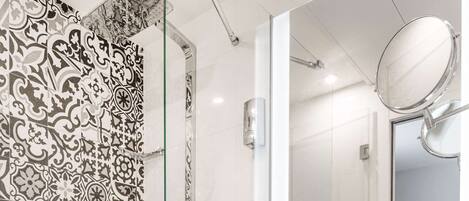 A modern bathroom with a shower, a sink, and a mirror.