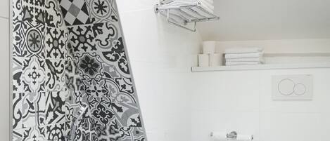 Un baño moderno con una bañera independiente, un inodoro y una ducha.
