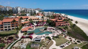 A resort with multiple buildings, a central pool area, and a beach. - Casa del Mar Condos (San José del Cabo)