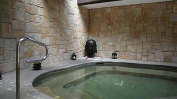 Relax by the serene pool surrounded by a natural stone wall and enjoy a peaceful atmosphere.