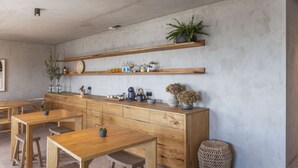 A modern kitchen with wooden cabinets, a central island, and built-in shelves above.