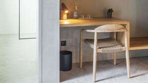 A wooden desk with a lamp, a bottle, and a small plant.