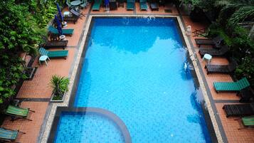 Alberca al aire libre y camastros