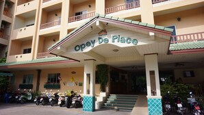 A multi-story building with a sign reading "Opey De Place" at the entrance. There are several motorcycles parked in front. - Opey De Place (Pattaya)