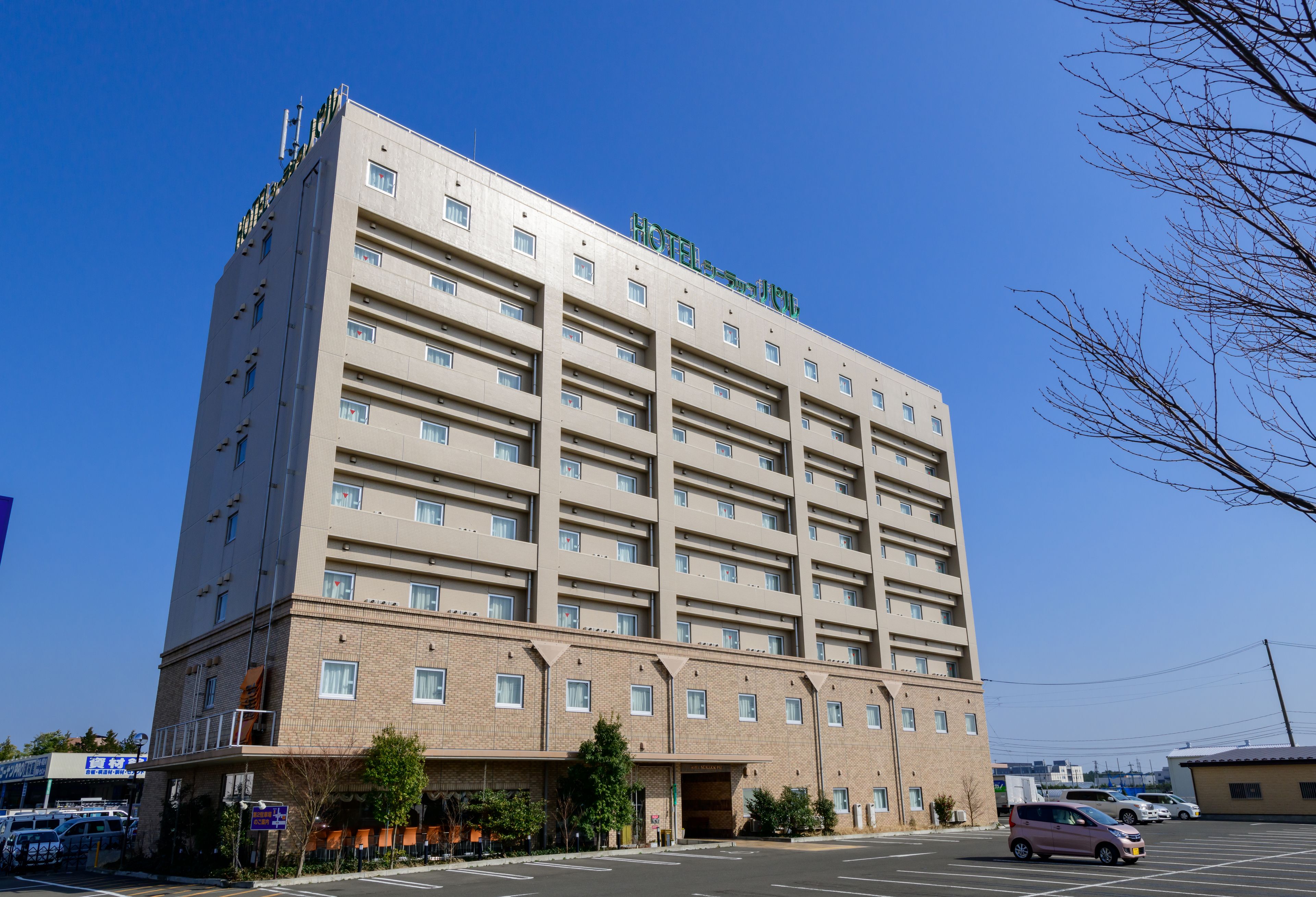A multi-story hotel with a flat facade, numerous windows, and a clear sky.