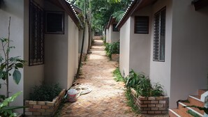 A narrow pathway flanked by buildings with barred windows, leading to a staircase. - Pattara House (Koh Samui)