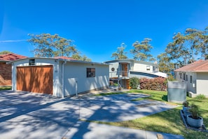 A residential area with a garage, a small shed, and a house with a red roof. - The Edgewater Bed & Breakfast (Sanctuary Point)