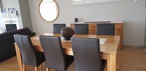 A dining area with a wooden table, black chairs, and a decorative vase. - The Edgewater Bed & Breakfast (Sanctuary Point)