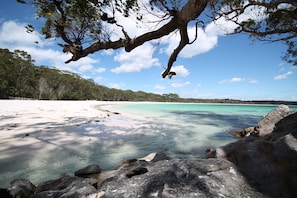 A beach with clear turquoise water, white sand, and rocky outcrops. - The Edgewater Bed & Breakfast (Sanctuary Point)