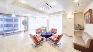A conference room with a round table, leather chairs, a potted plant, and a sofa. - Hotel Le Botejour Nanba (Osaka)