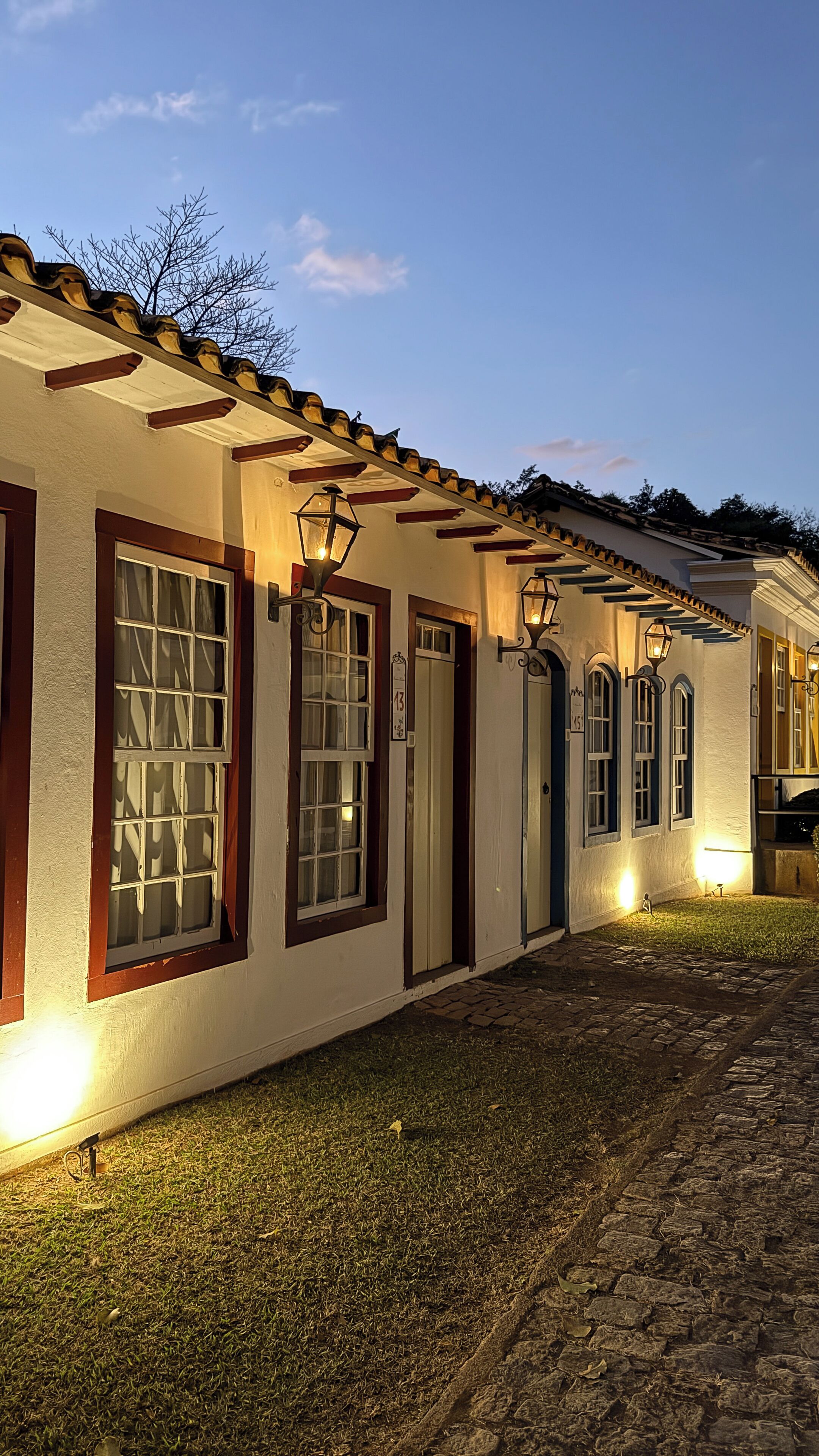 A building with multiple doors, each with a number sign, and a cobblestone pathway leading to the entrance.