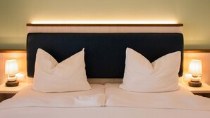 A hotel room with a bed, two bedside lamps, and a headboard. - BE BIO Hotel be natural (Toenning)